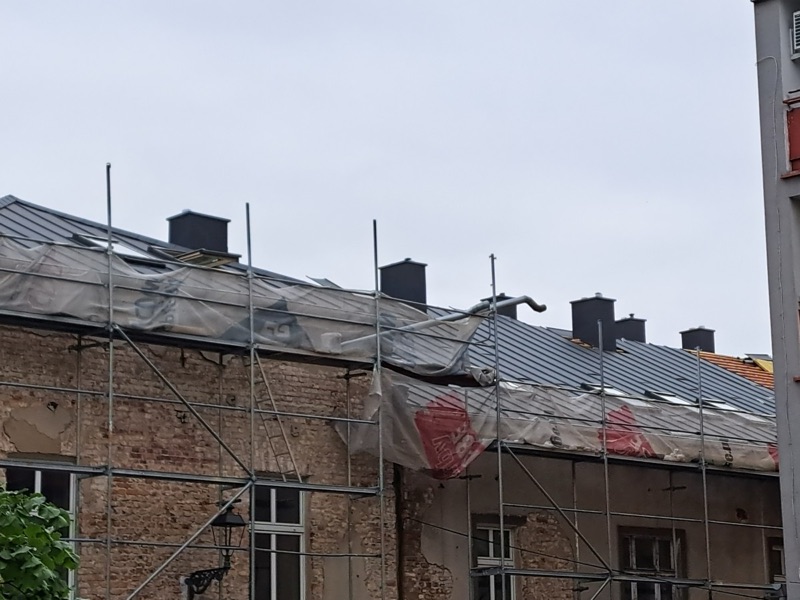 Grafitowe pokrycie z blachy na rąbek na kamienicy, przy elewacji rusztowania